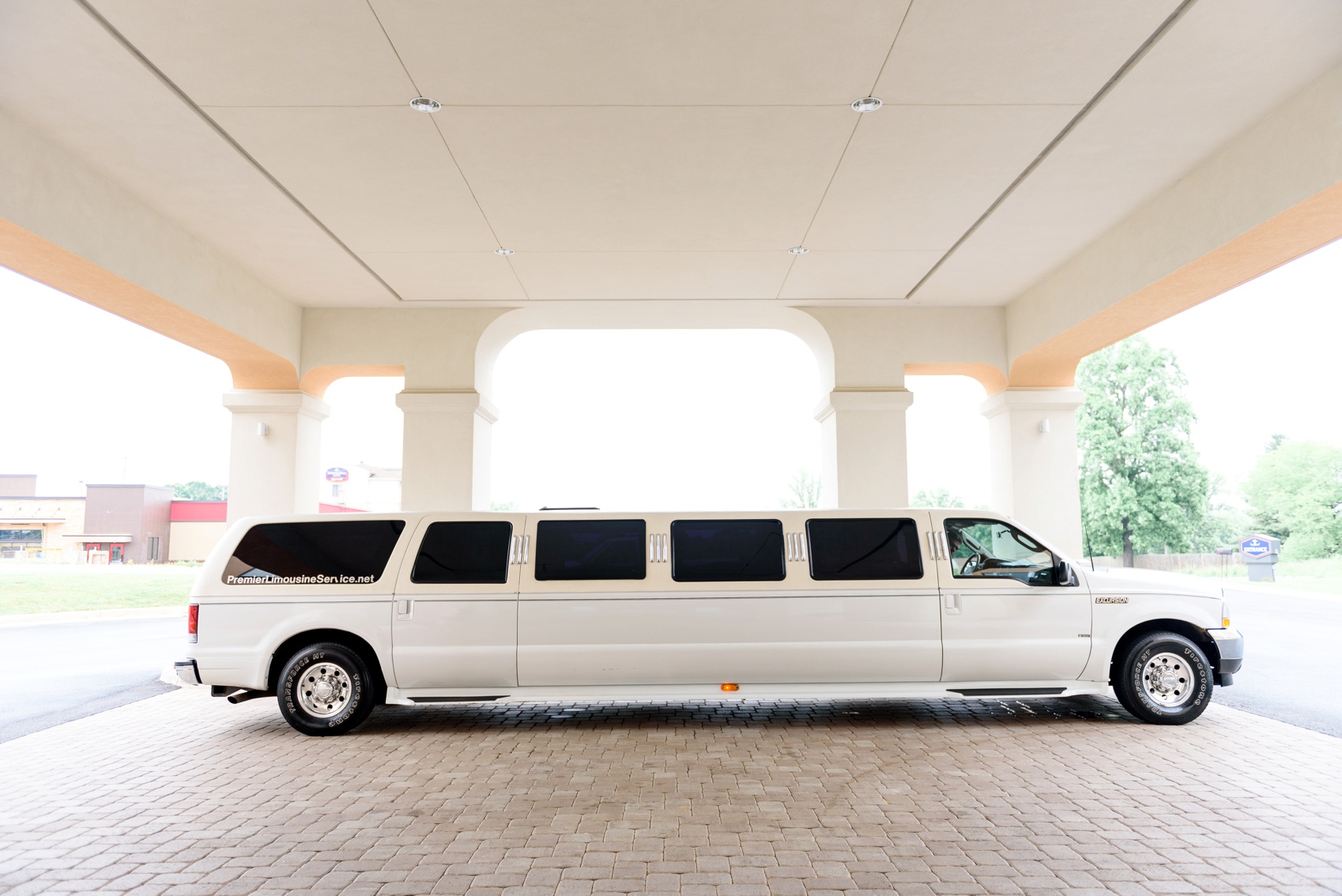 white limo transports bridal party to church