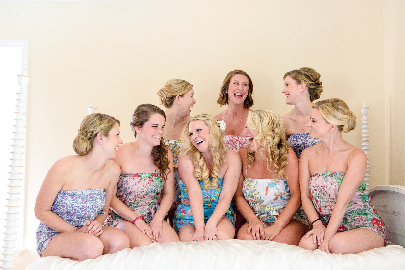 bride and bridesmaids laughing in bed