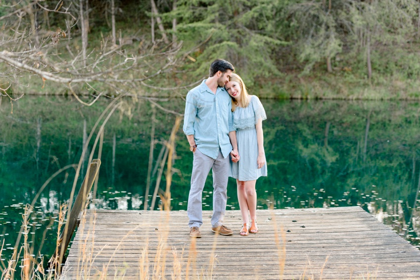photo of engaged couple standing on a pond in virginia