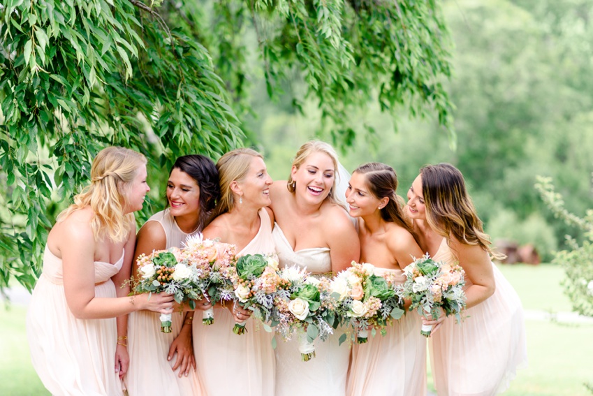 bridesmaids laughing wearing blush dresses