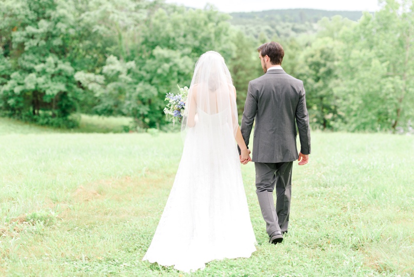 bride and groom walking in the field 