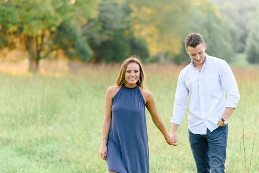 couple walking in the field and smiling