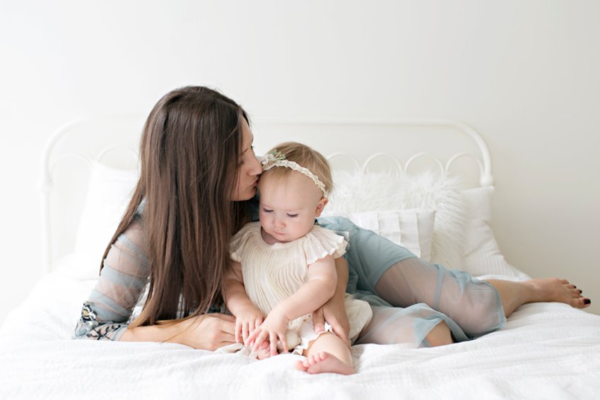 mom kissing baby girl for family photos