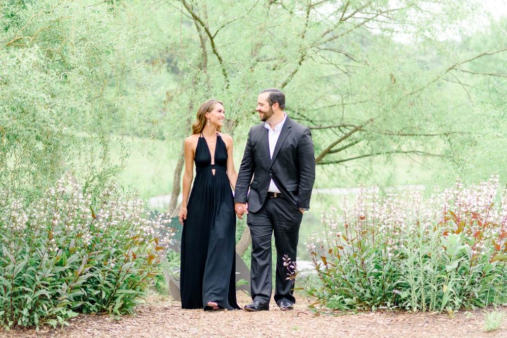 engaged couple smiling and walking at meadowlark botanical gardens