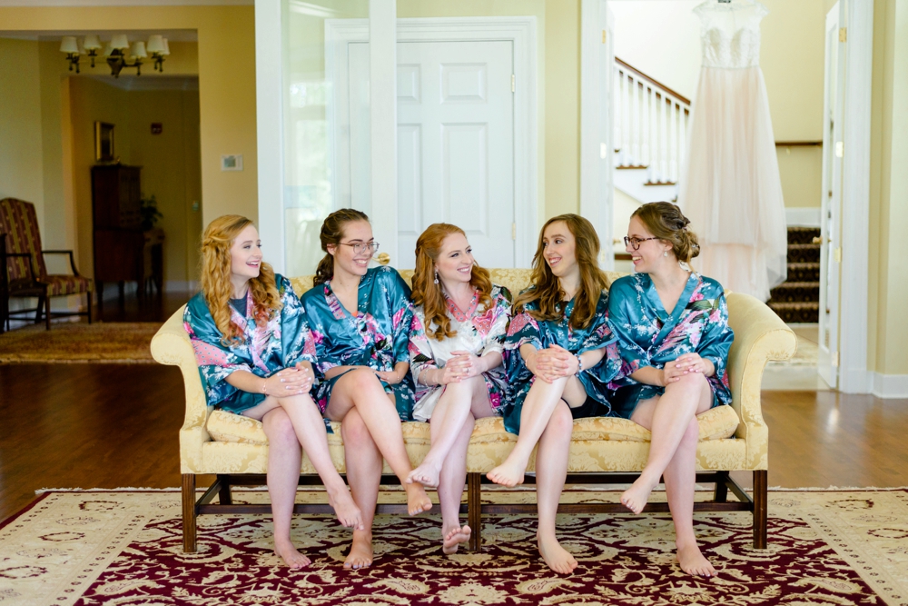 bridesmaids sitting on couch laughing 