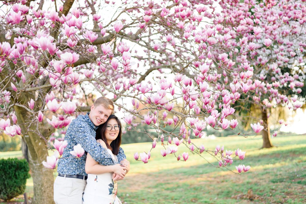 couple taking pictures near magnolia trees