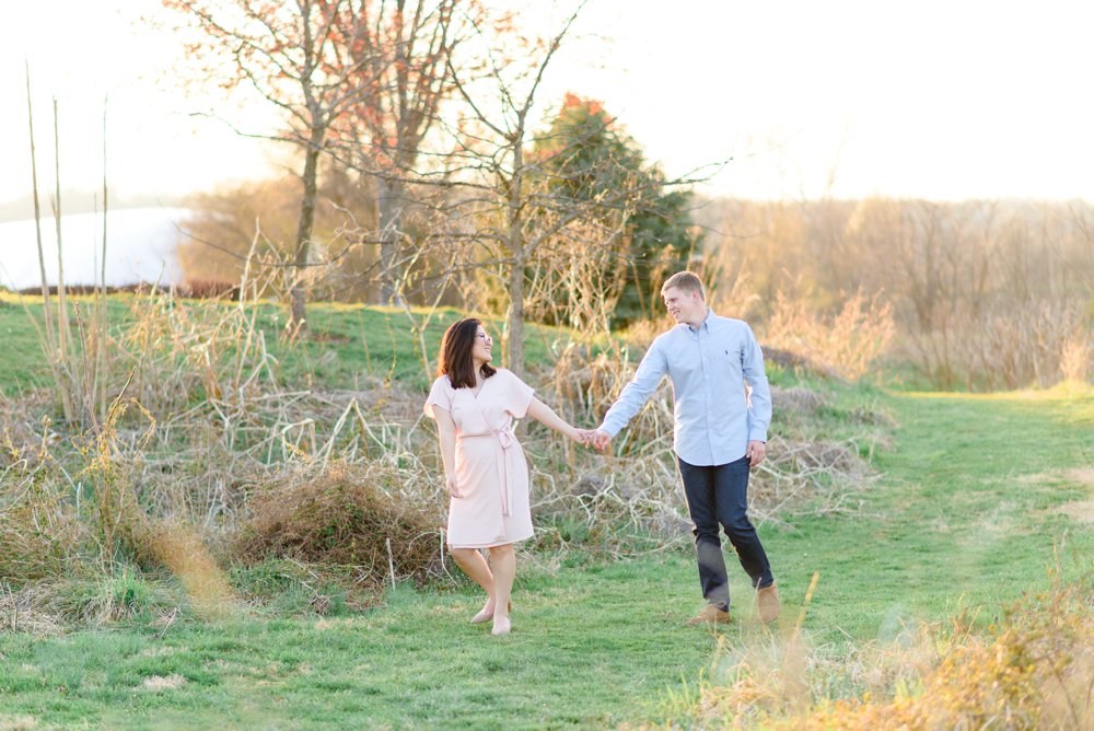 sweethearts walking in the field at sunset