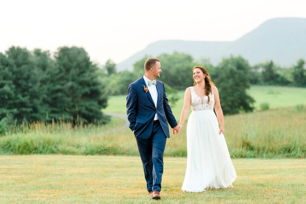 couple running through the field on wedding day