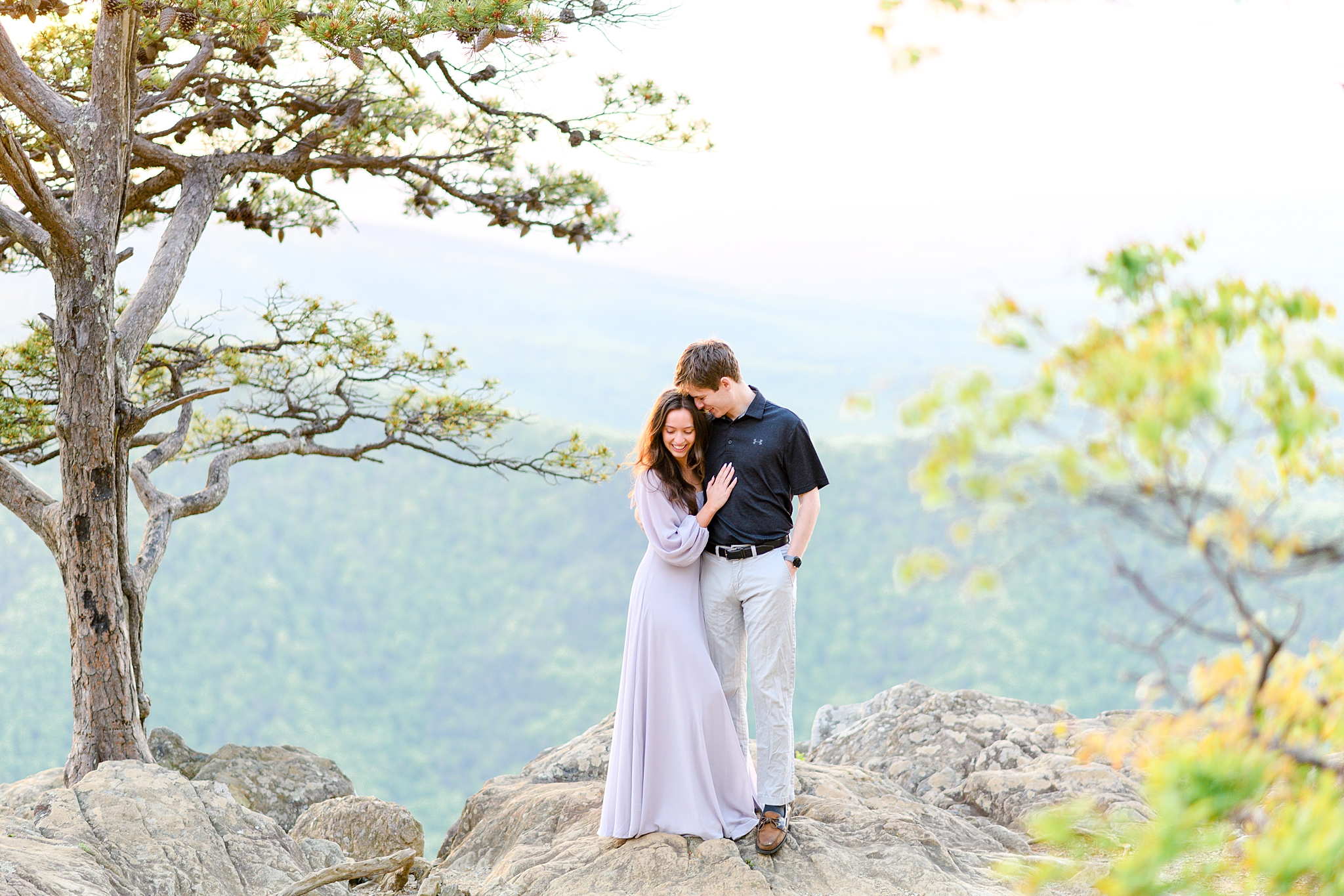 An intimate moment shared by the engaged couple surrounded by nature's beauty.