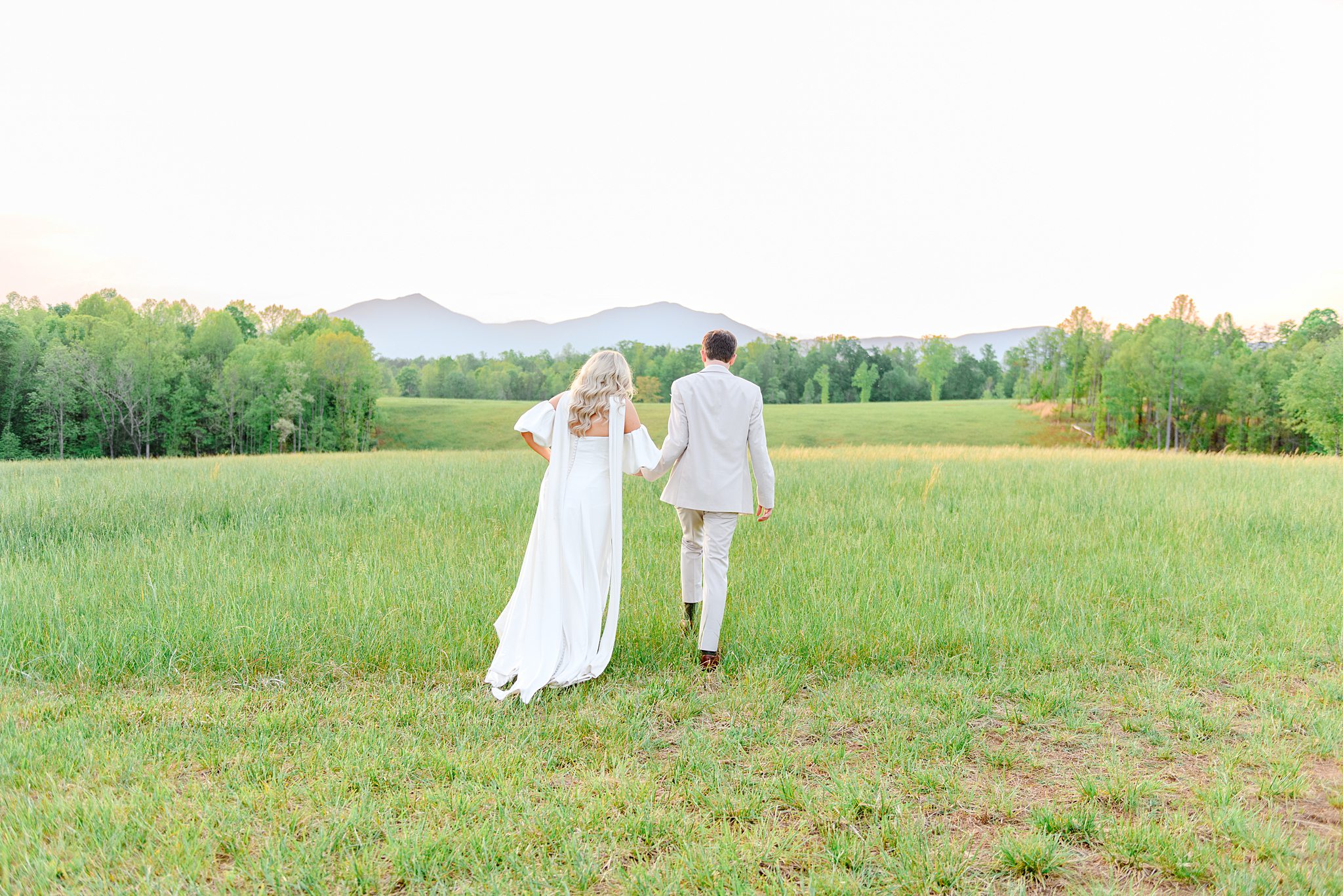 couple walking in the field at Cedar Oaks Farm in Bedford, VA