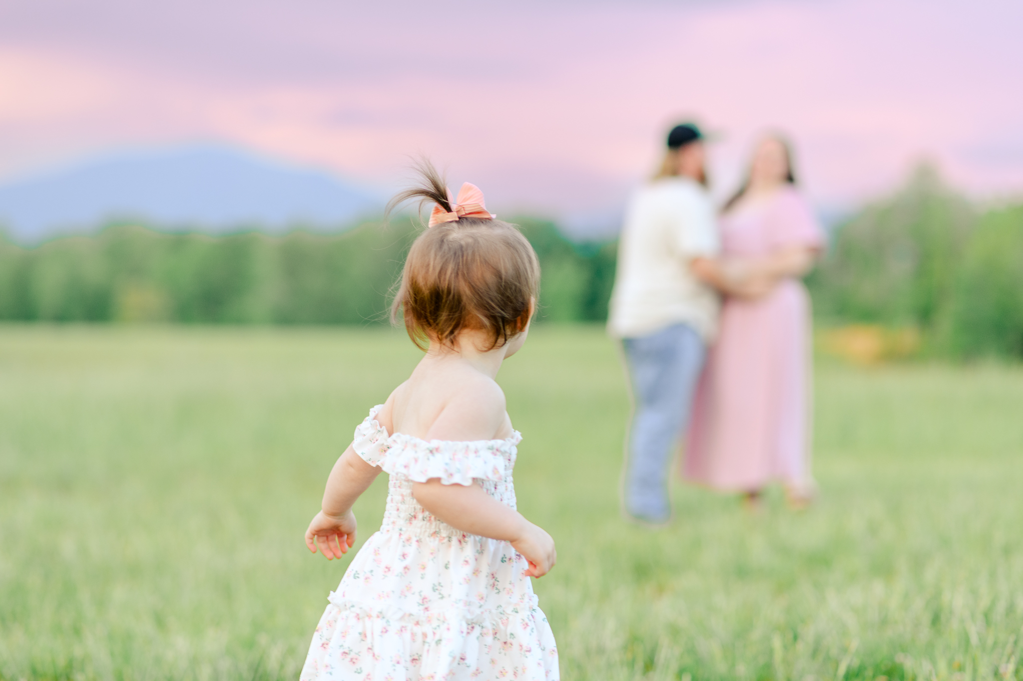 Toddler looking at parents in the field