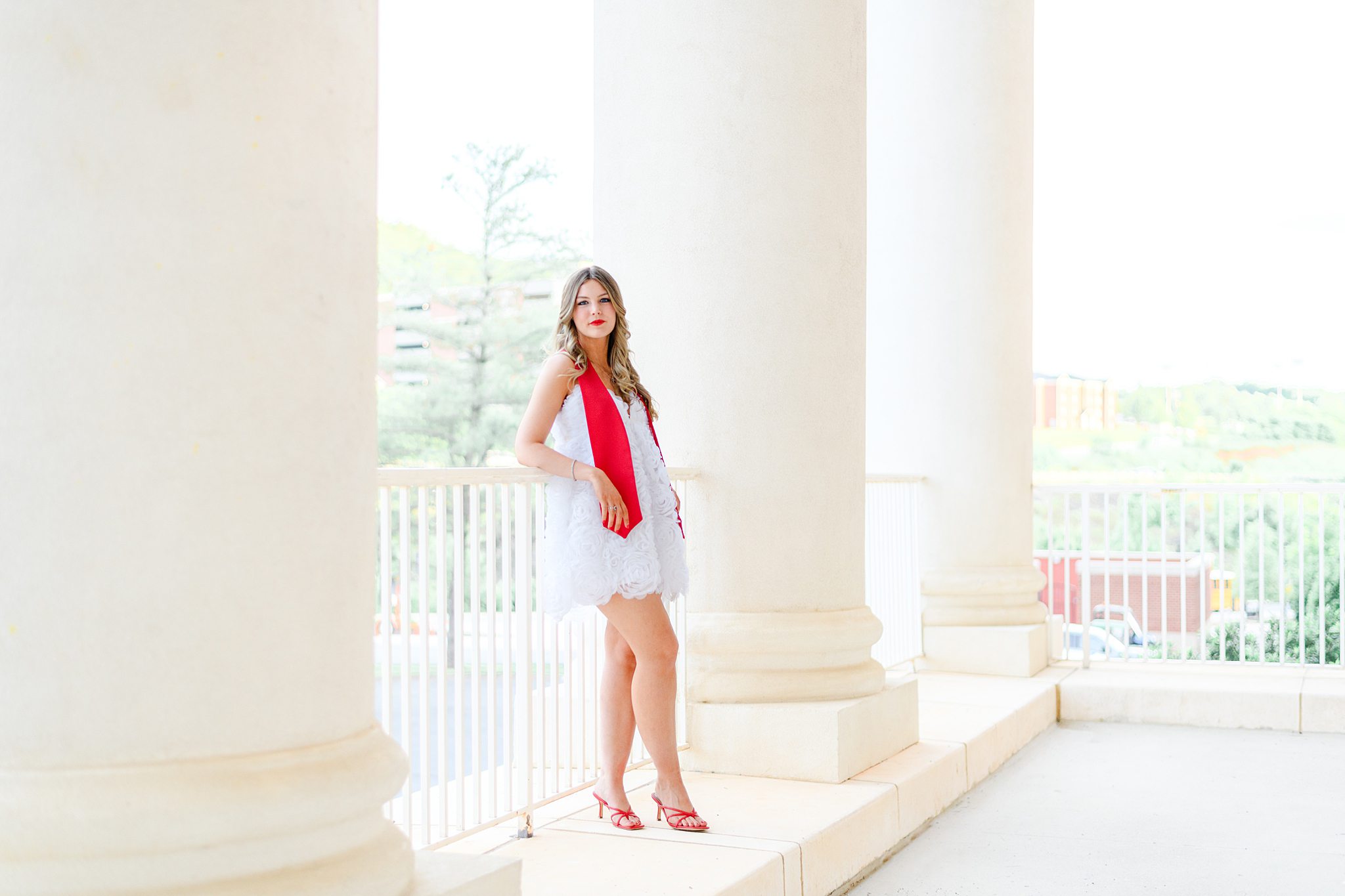 Liberty University graduation photos at golden hour with graduate posing at DeMoss Hall