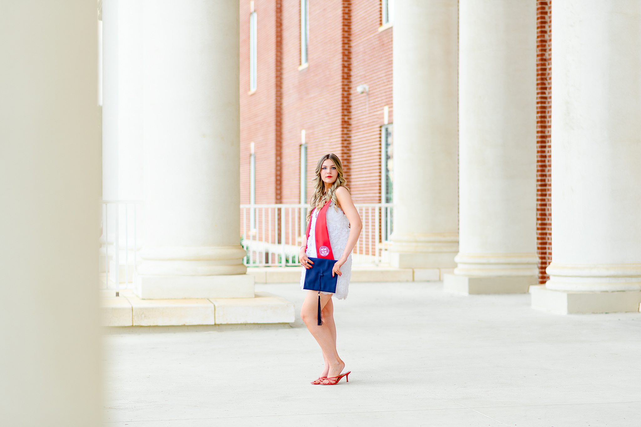 classic cap and gown shot in front of DeMoss
