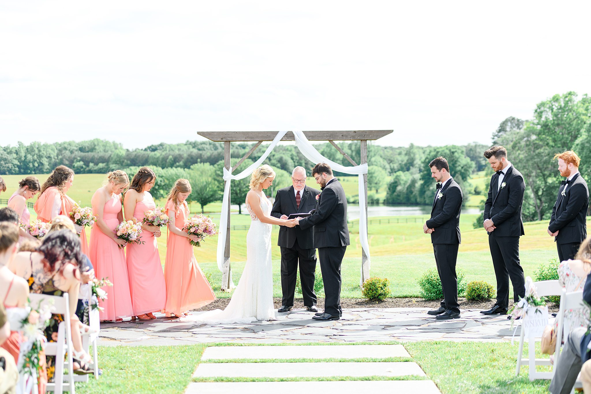 The couple exchanging vows under a sunny sky at Spring Grove