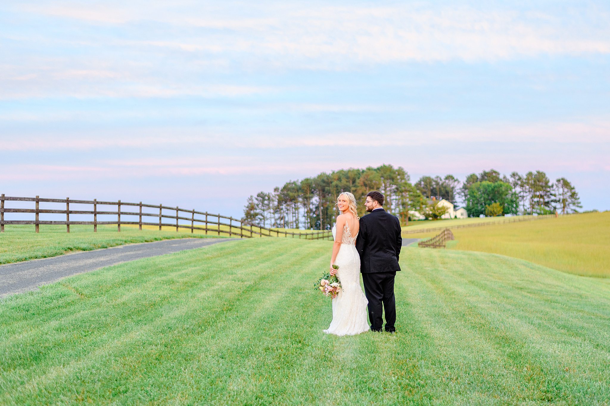Bride and groom holding hands, walking through the fields at Spring Grove during golden hour