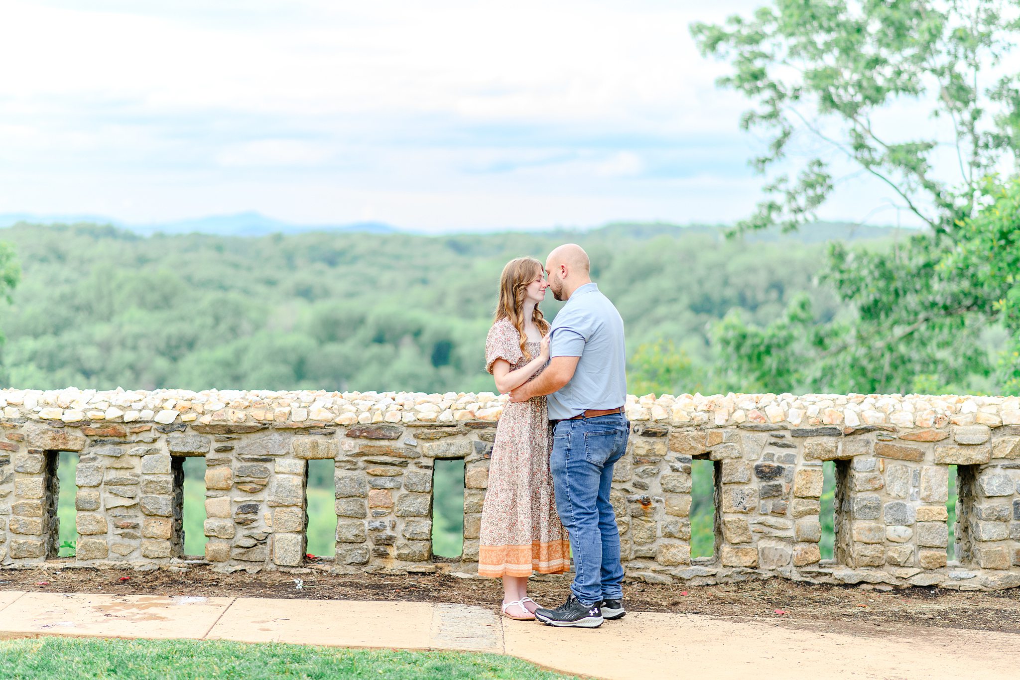 Couple standing in front of the old stone bridge, wrapped in each other’s arms