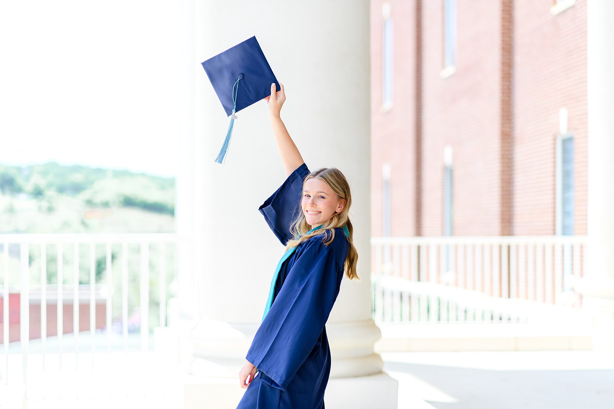 Liberty University graduate posing with cap and gown during spring graduation session