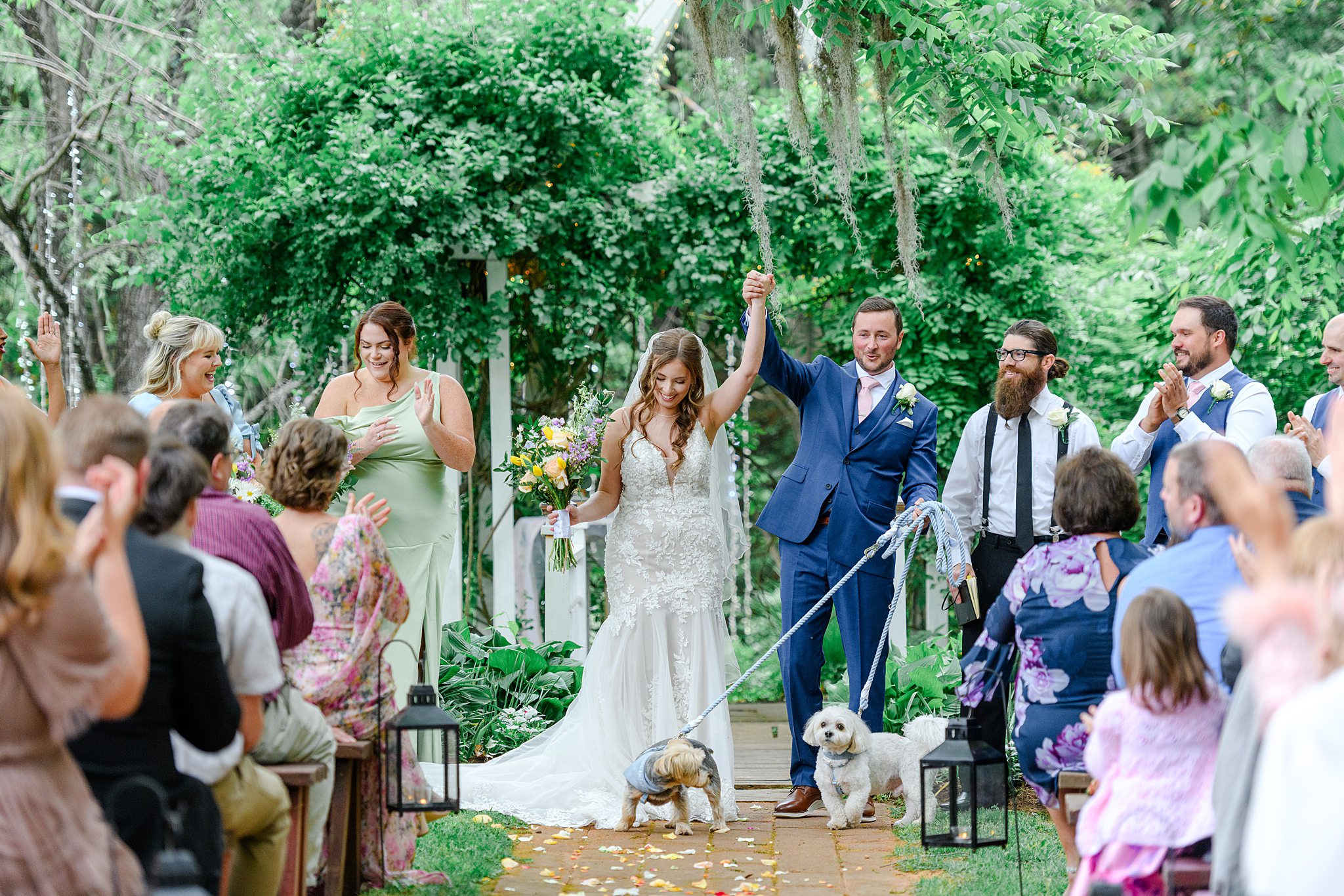 married couple walking down the aisle with dogs