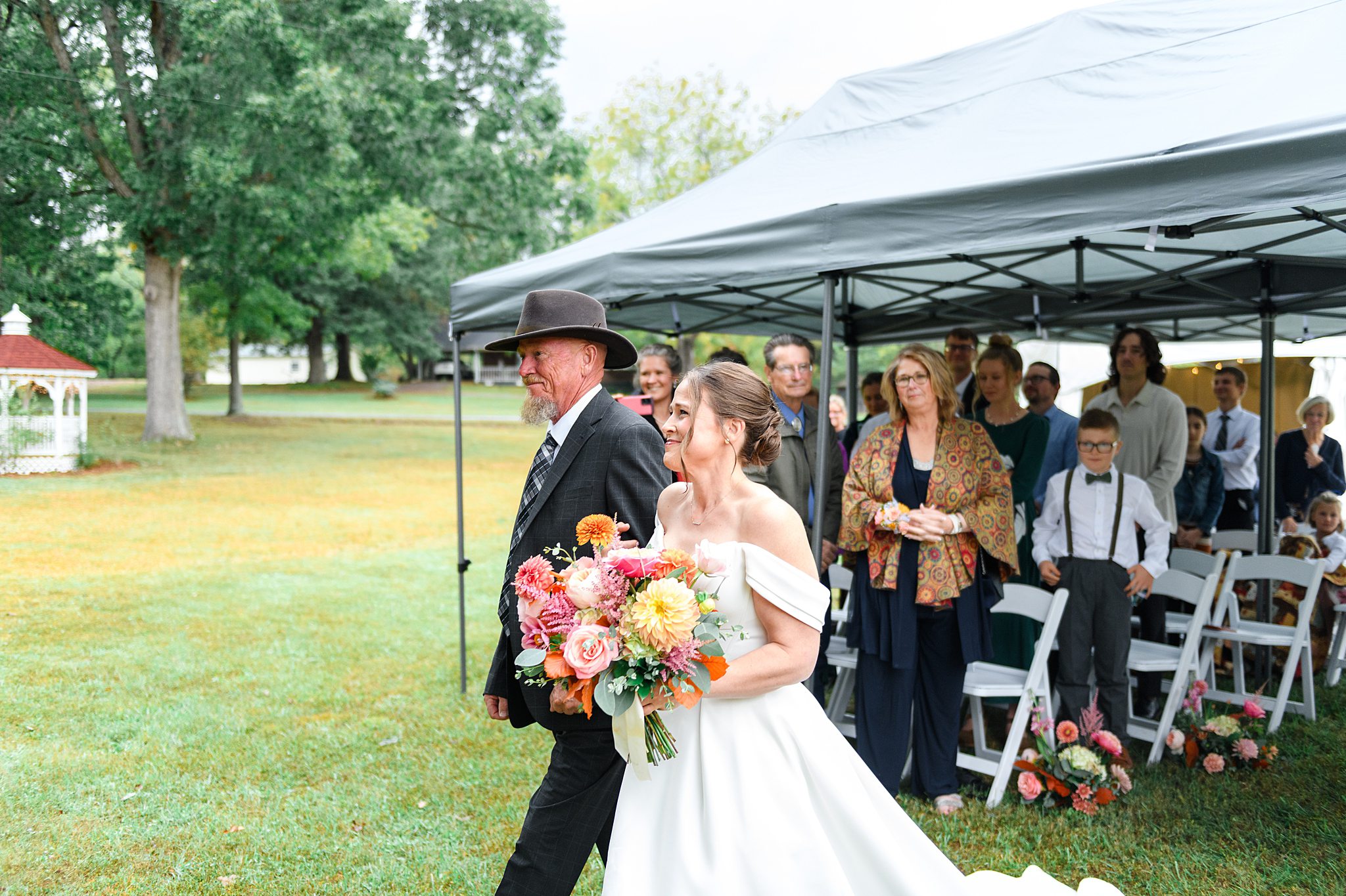 bride walking towards outdoor ceremony